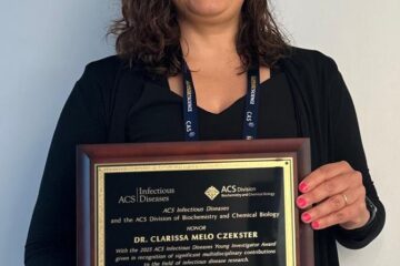 Clarissa holding the award