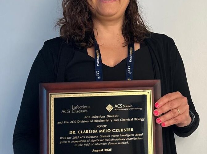 Clarissa holding the award
