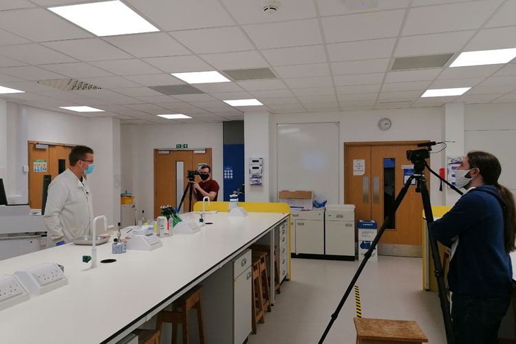 A biologist being filmed inside of a lab